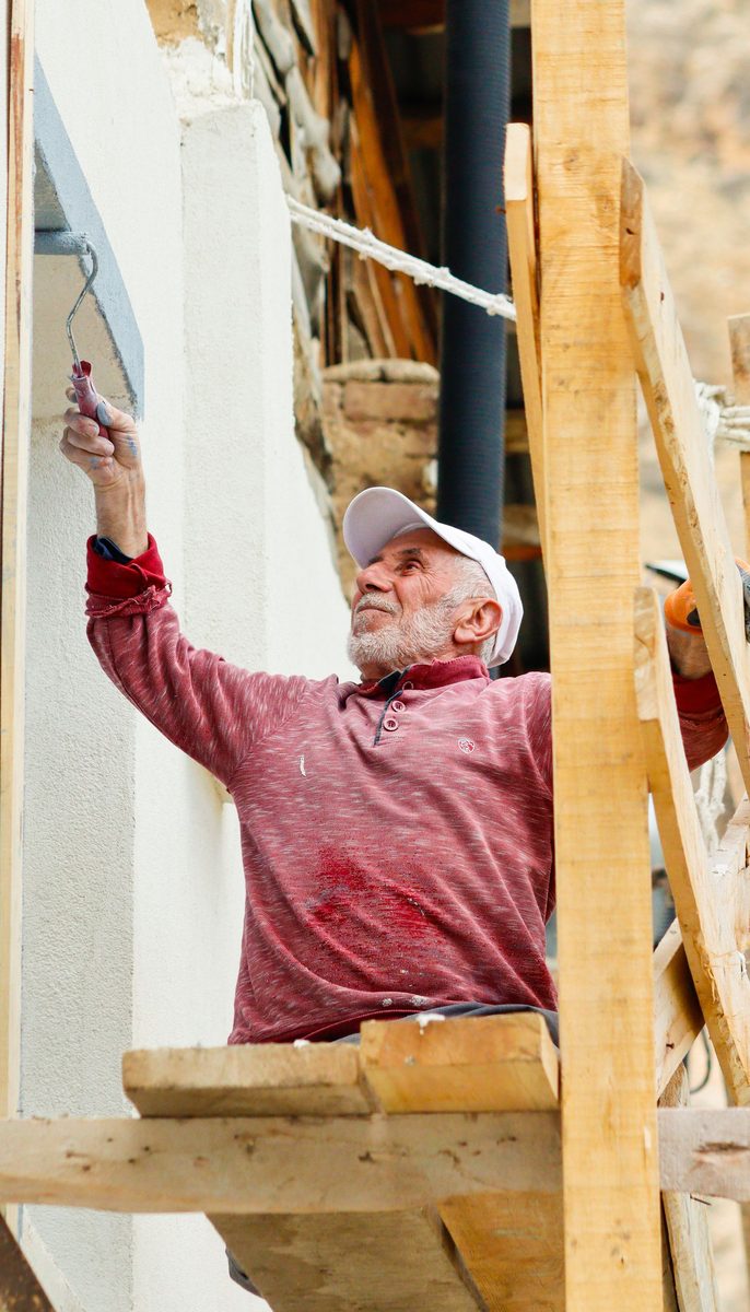 Painter on scaffolding at a building exterior